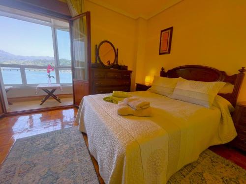 a bedroom with a bed with a view of the ocean at El Pescador in Ribadesella