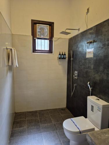 a bathroom with a toilet and a shower at Coastal Villa Mirissa in Mirissa