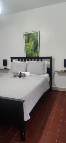 a bedroom with a large bed with white pillows at Sweet Sunset II- Rompeolas Beach in Aguadilla