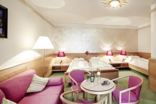 a hotel room with two beds and a table and chairs at Hotel Schrofenstein in Landeck