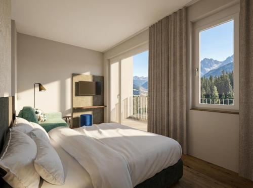 a bedroom with a large bed and a large window at Lasalt - Mountain Legends Hotel in Ischgl