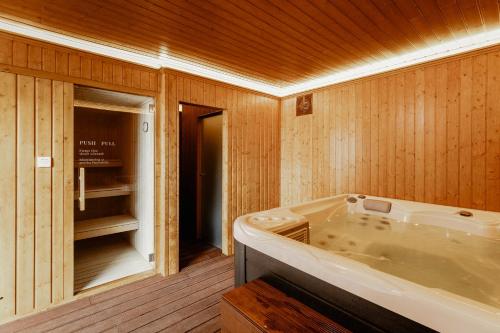 a bath tub in a room with wooden walls at Shellter Apartments by the sea in Vieira de Leiria