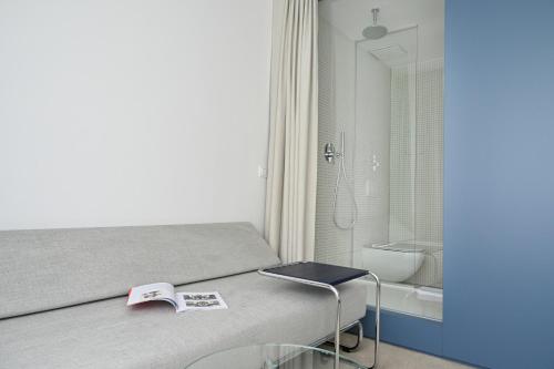 a bedroom with a bed with a book and a bathroom at Hotel SOREA MORAVA in Tatranská Lomnica