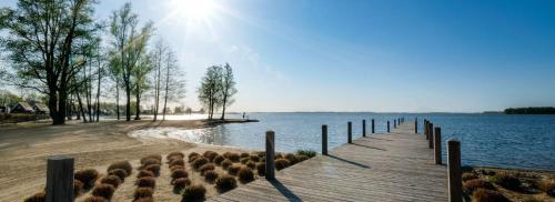 a dock with the sun shining over a body of water at Luxus Chalet Visarend 13 Strandkristall in Hulshorst