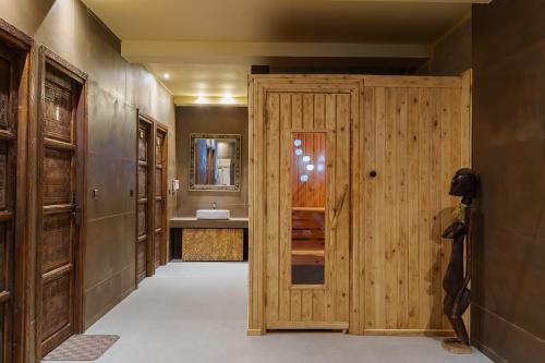 a bathroom with a wooden door and a sink at Hotel Xaluca Dades in Boumalne Dades