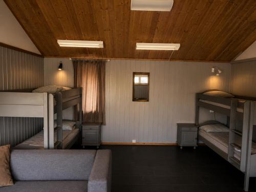 a room with three bunk beds and a couch at Haraldvollen Red Cross Center in Bardufoss