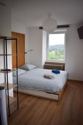 a bedroom with a bed and a large window at L'atelier de Mathieu meublés de tourisme classés in Saint-Rémy-sur-Durolle