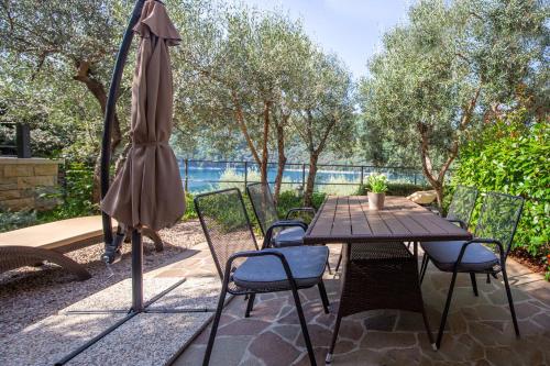 a table with chairs and an umbrella on a patio at Istria Sea Side Apartments Lina in Labin