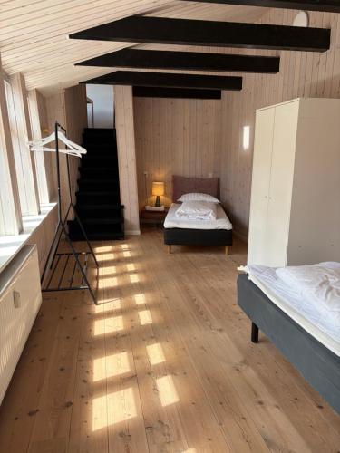 a large room with two beds and a staircase at Slotsgaarden ved Hesten in Randers