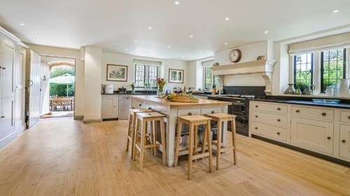 a large kitchen with a large island with bar stools at Grindstone Mill in Alderley