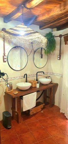 a bathroom with two sinks and two mirrors at Casa Rural La Changa in Losar de la Vera