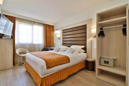 a hotel room with a large bed and a television at Best Western Plus Cannes Riviera & SPA in Cannes