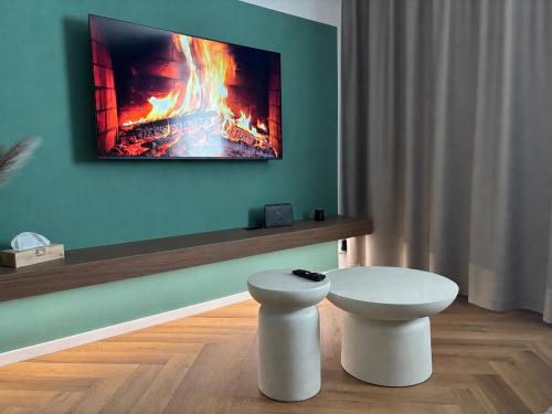 a living room with a table and a fire painting on the wall at APARTMENT A&D Monaco in Poprad