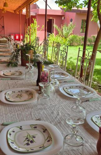 a table with plates and wine glasses on it at Domaine JJ Marrakech in Marrakesh