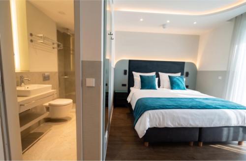 a bedroom with a large bed and a bathroom at H24 Hotel Berlin Grünau in Berlin