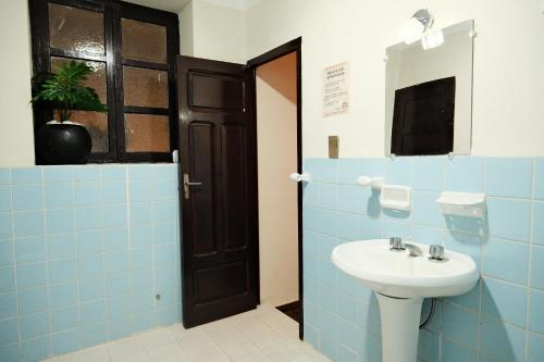 a bathroom with a sink and blue tiles at Hotel Pata y Perro in Tarija