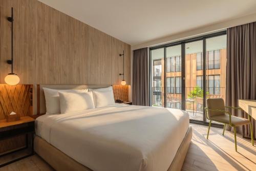 a bedroom with a large bed and a large window at Craftsman Bangkok in Bangkok