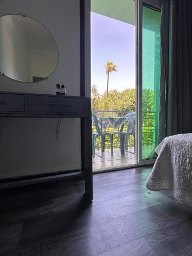 a bedroom with a dresser with a mirror and a balcony at Chambre du jardin in Rabat