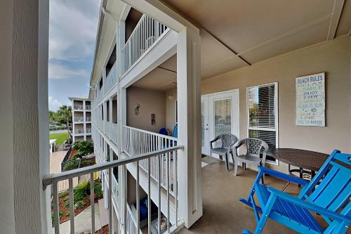 a balcony with two blue chairs and a table at Grand Caribbean Perdido Key #306 West in Perdido Key