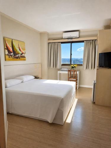 a bedroom with a large white bed and a television at klein Ville Esteio Br in Esteio