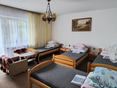a hospital room with three beds and a table at Agroturystyka u Mańka in Suwałki