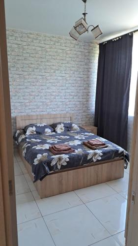 a bed in a bedroom with a brick wall at Urban Harmony in Tsalka
