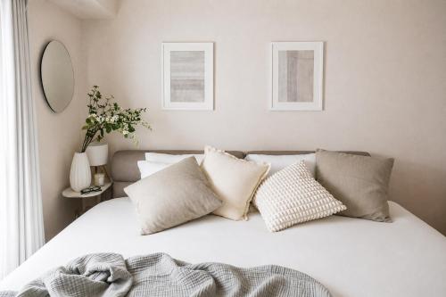 a bedroom with a white bed with pillows at Miroku Nagoya in Minami-sotoborichō