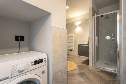 a bathroom with a washing machine and a shower at GuestHost - Vivaldi Inverno Apartment in Treviglio