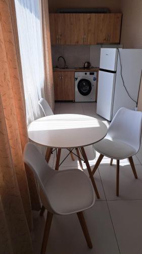 a kitchen with a table and two chairs and a refrigerator at Urban Harmony in Tsalka