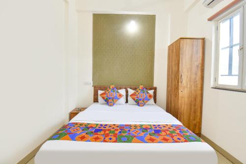 a bedroom with a bed with a colorful bedspread at FabHotel Tiru Rooms in Pune