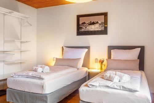 two beds in a room with white sheets at Hesselberg-Oase Ferienhof Hüttner in Röckingen