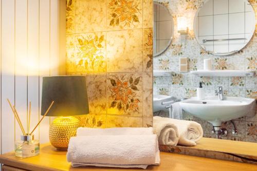 a bathroom with a sink and a table with a lamp at Hesselberg-Oase Ferienhof Hüttner in Röckingen