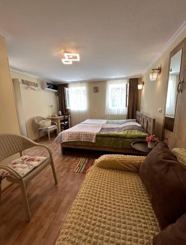 a bedroom with two beds and a couch and a table at Guest House Panda in Kutaisi