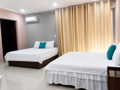a bedroom with two beds and a window at Logo Luxury Guesthouse in Windhoek