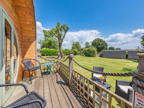 a deck with chairs and a table on a house at The Pod At Egmont in Newenden