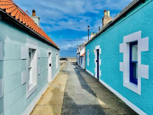 eine Reihe blauer Gebäude an einer Straße in der Unterkunft Jebel in Cullen