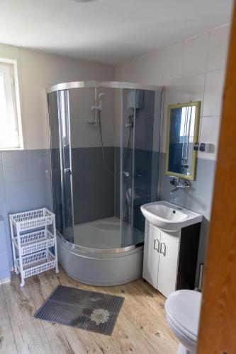 a bathroom with a shower and a sink at Leśna Oaza in Sasino