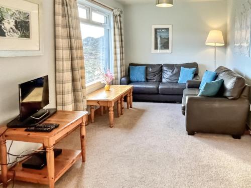 a living room with a couch and a table at Orchid Cottage - Uk5866 in Achmelvich