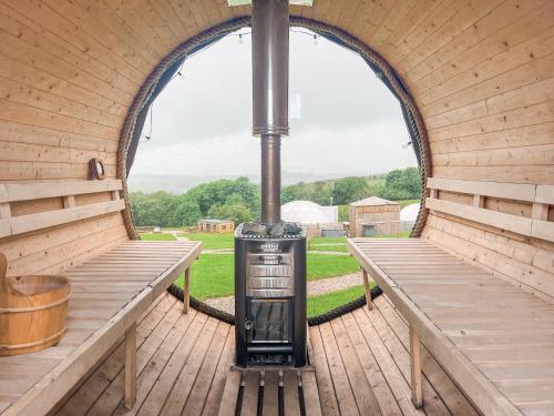an inside of a wooden igloo with two benches at Pendle Hill Dome - Ukc9599 in Earby