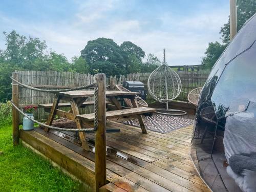 a picnic table on a wooden deck with a swing at Pendle Hill Dome - Ukc9599 in Earby
