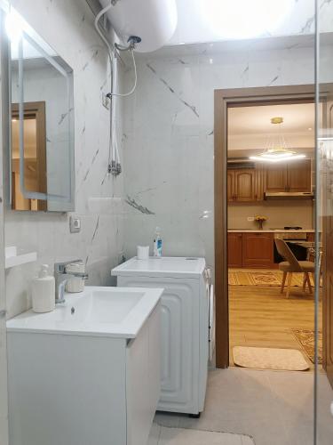 a white bathroom with a sink and a washing machine at Arthouse Elbasan in Elbasan