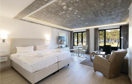 a bedroom with a large white bed and a living room at Baltic in Binz