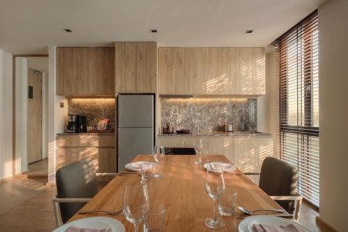 a kitchen with a wooden table with wine glasses on it at Craftsman Bangkok in Bangkok