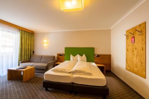 a hotel room with a bed and a couch at Hotel Mozart in Landeck