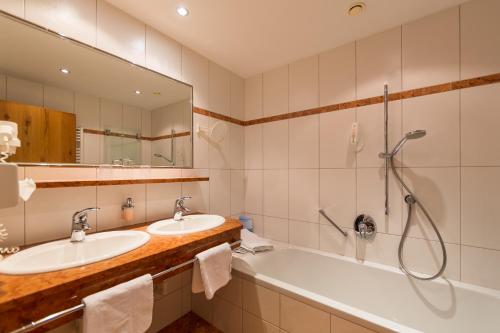 a bathroom with two sinks and a shower at Hotel Mozart in Landeck