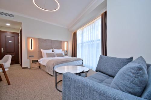 a hotel room with a bed and a couch and a table at BM Avenue Hotel in Yerevan