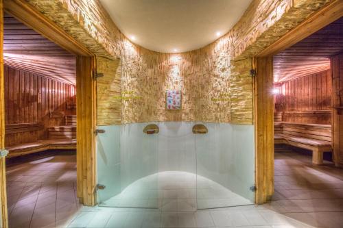 bagno con doccia in una camera con pareti in legno di Hotel Gołębiewski Wisła a Wisła