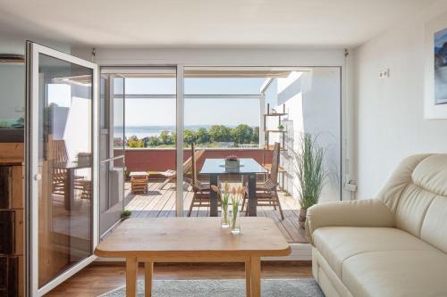 a living room with a coffee table and a balcony at Apartment Lichterfunkeln für junge Paare mit Panorama-Seeblick in Daisendorf