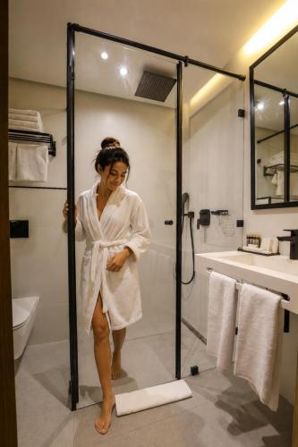 a woman standing in a bathroom with a shower at ADAY Hotel Casablanca in Casablanca