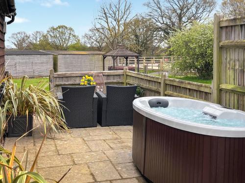 a hot tub in a yard with a fence at The Lodge in Northiam